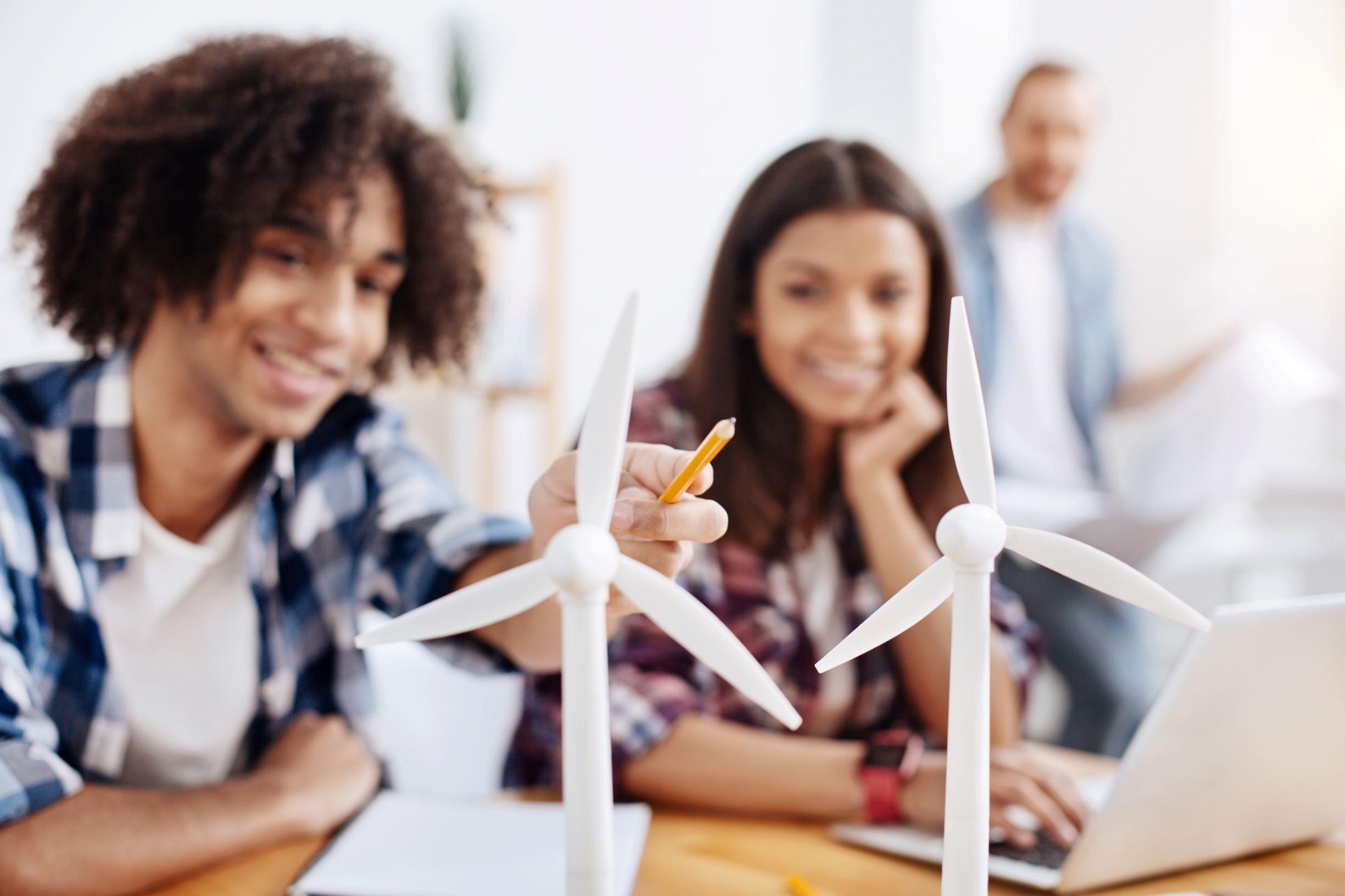 Two students discussing over a wind turbine 
